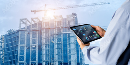 Smart Construction Project management system concept.Hands using digital tablet with Construction Management Software on blurred construction site as background