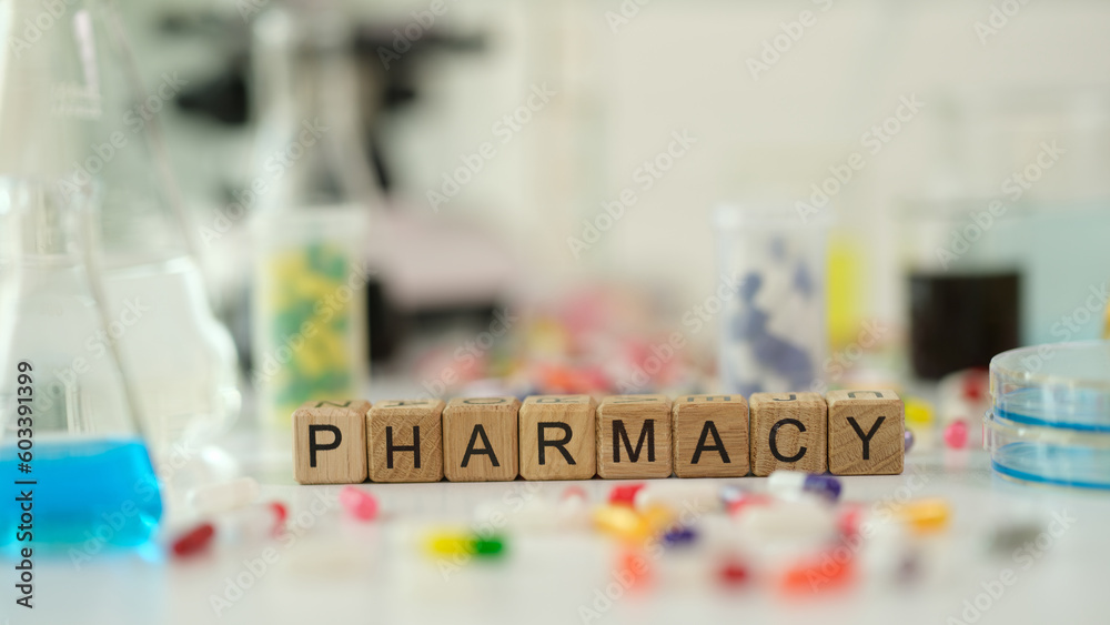 Pharmacy word on wooden cubes near many medicines. Pharmaceutical industry concept