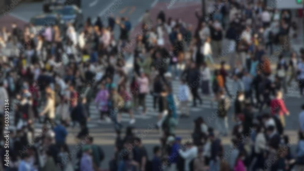 Blurred defocused view of elevated view of a bustling crowd of people in the famous Shibuya Crossing in Japan during the daytime, densely packed and moving quickly through the streets. Blurred defocused view of elevated view of a bustling crowd of people in the famous Shibuya Crossing in Japan during the daytime, densely packed and moving quickly through the streets.