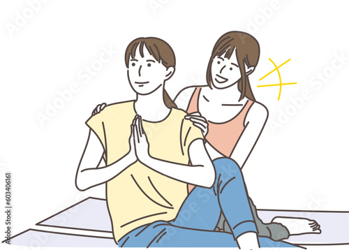座りながらヨガの指導をする若い女性と生徒
