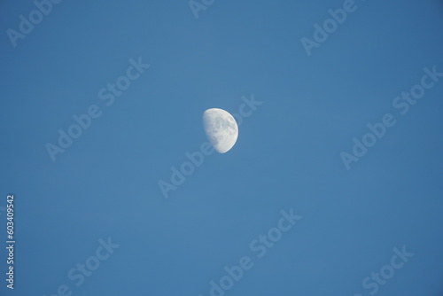 The blue sky view with the curve white moon in the sky in the day
