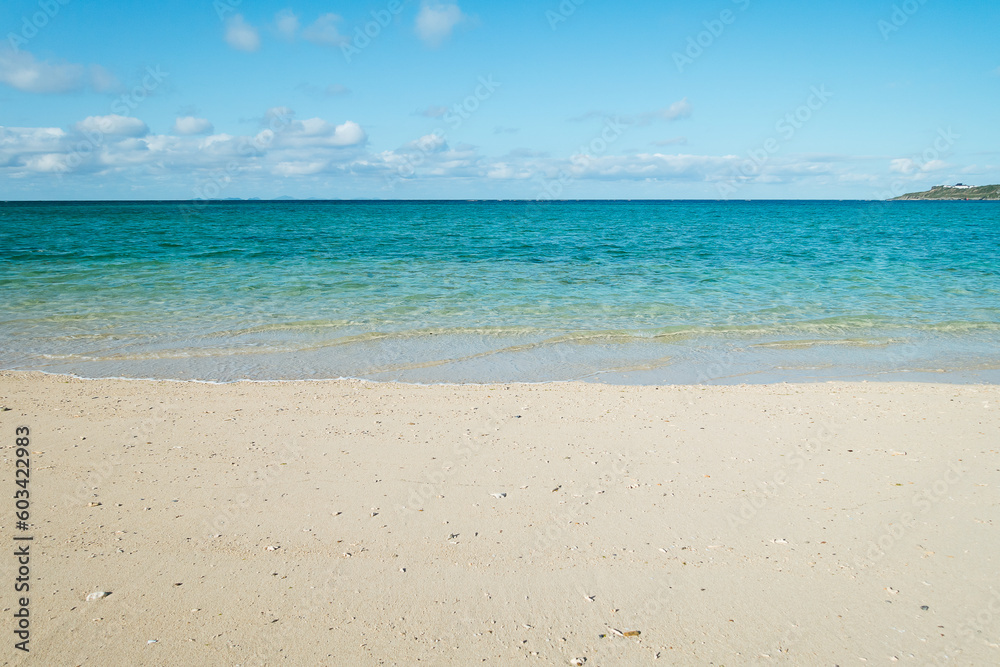 Empty white sandy beach with blue sky and white clouds