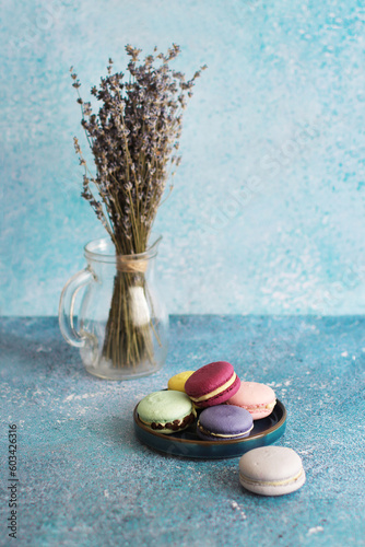 Colored macaroons on turquoise background and bouquet of lavender on background