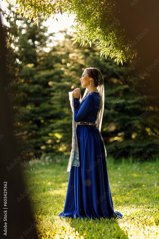 a girl in a blue dress in a spring forest