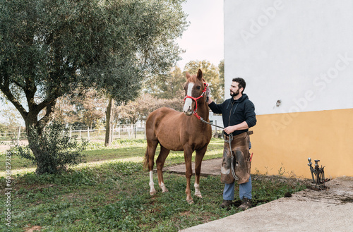 Man holding horse at stable photo