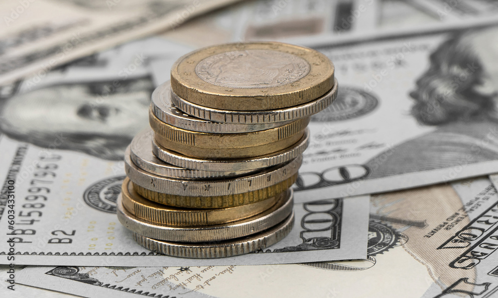 Stack of golden coins on dollar bills on a table. Stack of golden coins on dollar bills on a table.