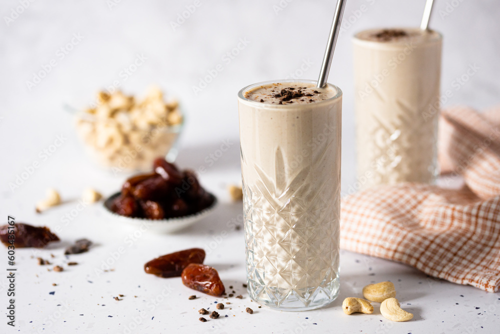 Glass full of a Creamy Cashew Smoothie Infused with Sweet Dates Delight, healthy, creamy, white and plant based for vegan people - obrazy, fototapety, plakaty 