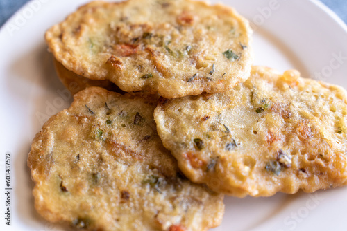 Closeup of salted codfish fritters on a white ceramic plate. A traditional Jamaican dish often referred to as stamp and go. photo