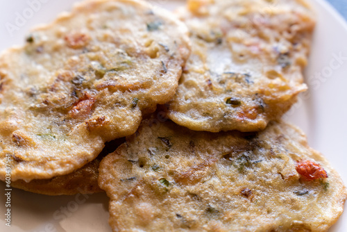 Closeup of salted codfish fritters on a white ceramic plate. A traditional Jamaican dish often referred to as stamp and go.