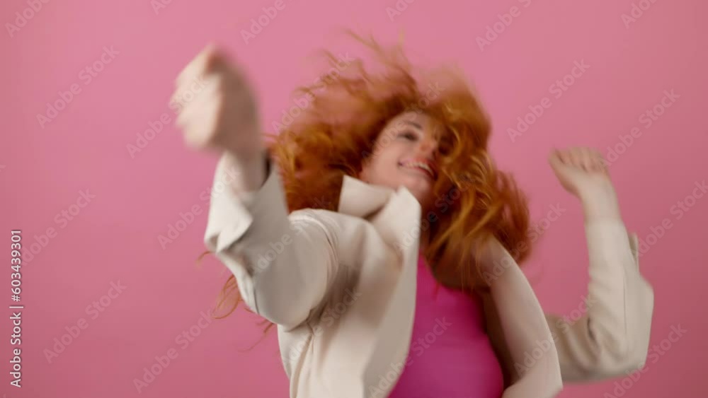Success, dancing and woman celebration winning, excited. Female model emotional having fun enjoying dance, smiling for freedom, discount, sale or entertainment in studio isolated on pink background Success, dancing and woman celebration winning, excited. Female model emotional having fun enjoying dance, smiling for freedom, discount, sale or entertainment in studio isolated on pink background