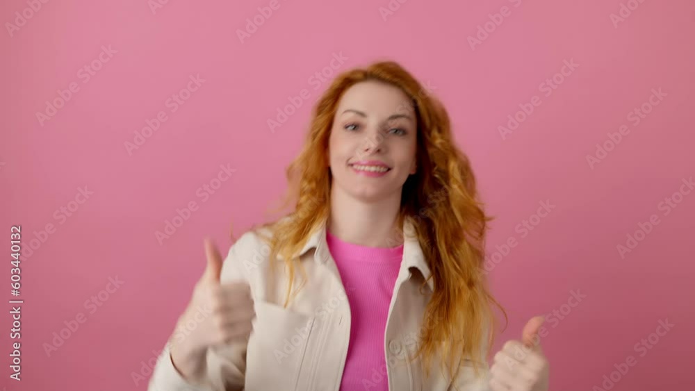 Yes gesture and winner woman smiling nodding, say Yes. Excited happy young ginger lady showing approving gesture, thumbs up, for victory, success. Indoor studio shot isolated on pink background Yes gesture and winner woman smiling nodding, say Yes. Excited happy young ginger lady showing approving gesture, thumbs up, for victory, success. Indoor studio shot isolated on pink background