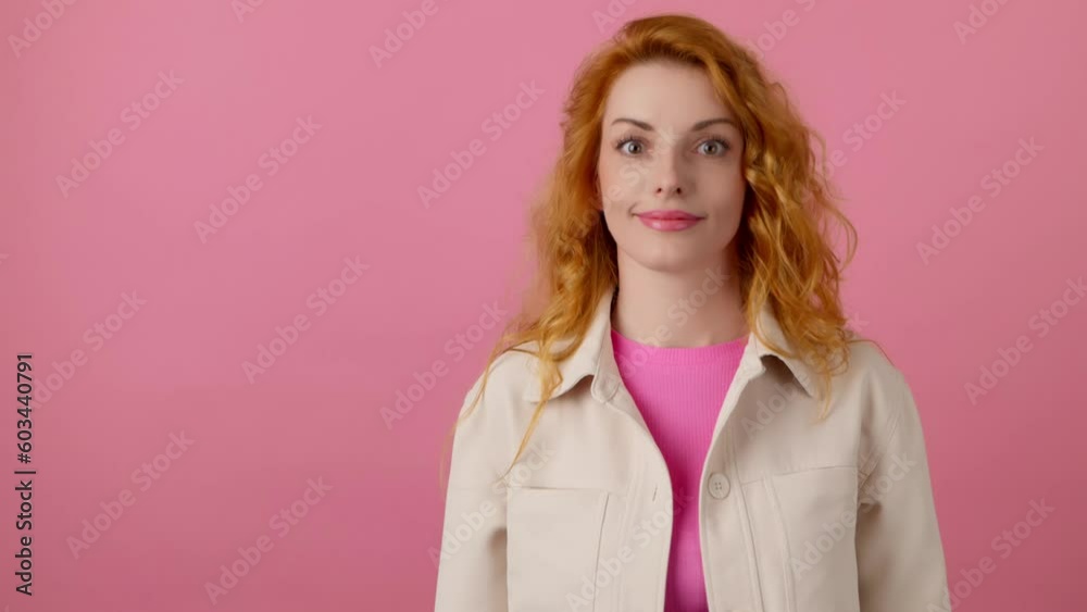 Woman and pointing at mockup workspace for advertisement, marketing, promotion or text. Female ginger model happy smiling showing mock up for news deal of offer in studio on pink background Woman and pointing at mockup workspace for advertisement, marketing, promotion or text. Female ginger model happy smiling showing mock up for news deal of offer in studio on pink background