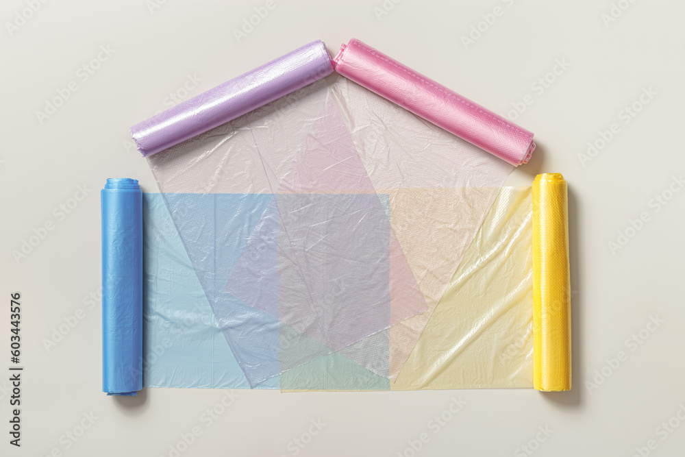 Colorful plastic bags in rolls as shape home on beige Eco plastic product bio bags for food, Plastic free environment protection concept, eco trend to reduce disposable plastic.