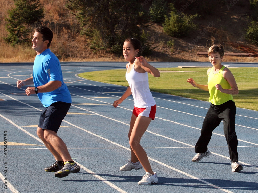 Obraz premium Mother, father and daughter exercising on a blue racetrack