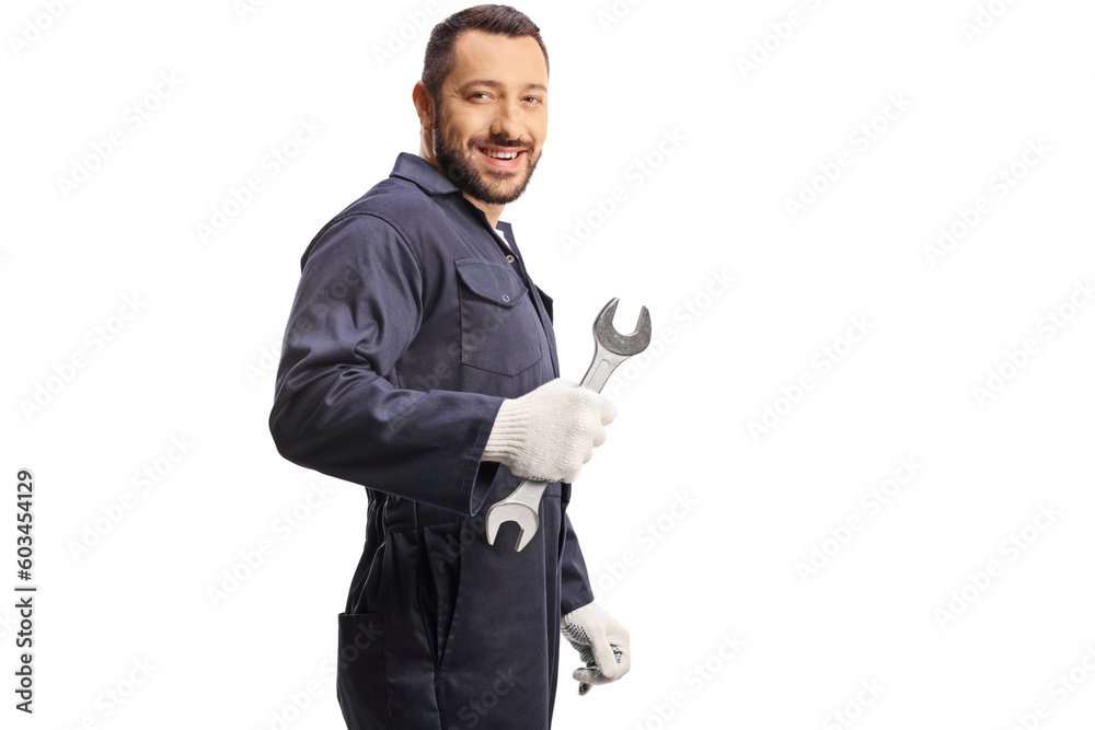 Car mechanic holding a wrench and looking over shoulder Car mechanic holding a wrench and looking over shoulder