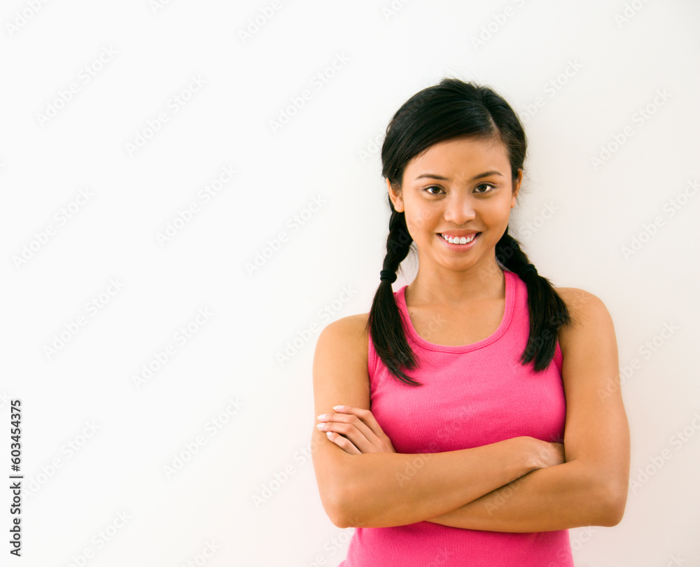 Portrait of young woman standing with arms crossed smiling. Portrait of young woman standing with arms crossed smiling.