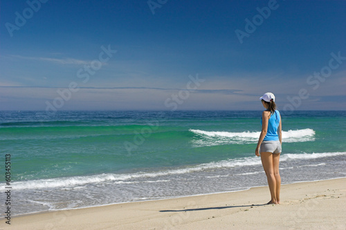Beautiful woman walking on the beach feeling the breeze