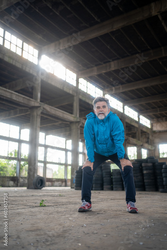 Portrait of a smiling mature male athlete resting after run © Nenad