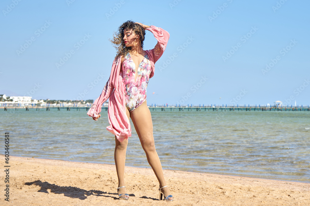 Close up summer fashion image of stunning sexy woman, posing on beach, wearing luxury stylish silk blouse and bikini, vacation glamour style Close up summer fashion image of stunning sexy woman, posing on beach, wearing luxury stylish silk blouse and bikini, vacation glamour style