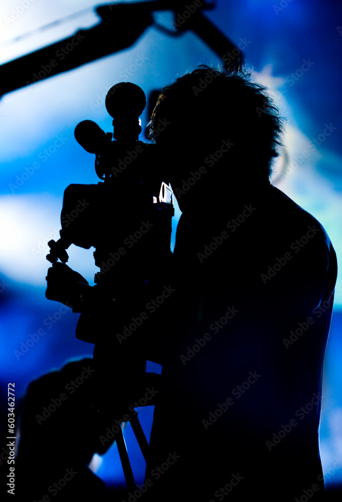 Silhouette of a cameraman filming fashion show catwalk