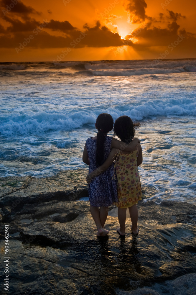 two girls in the beach at sunset