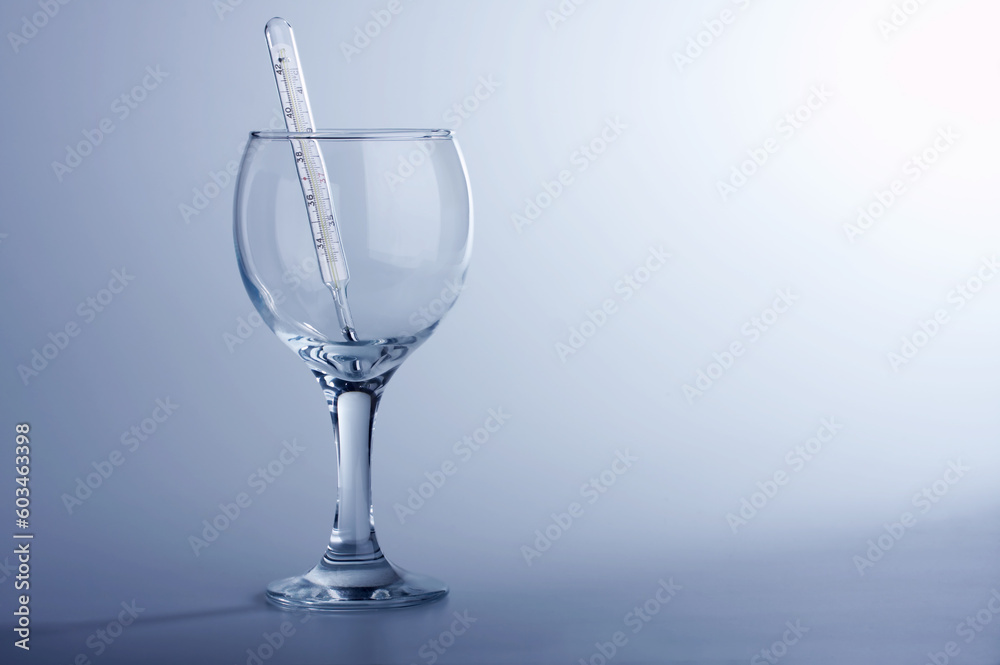 Obraz premium The thermometer in a glass on a blue background