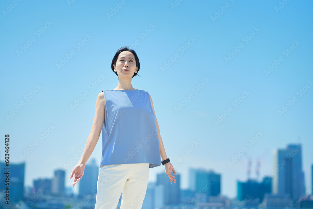 青空の下、リラックスした表情の女性 青空の下、リラックスした表情の女性