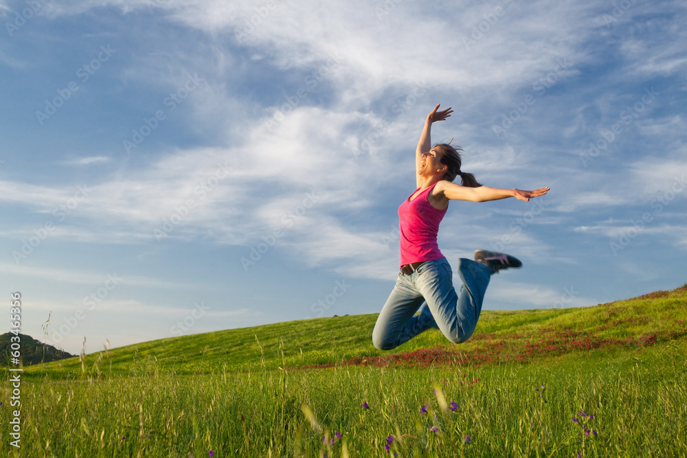 Beautiful young woman jumping on the field Beautiful young woman jumping on the field