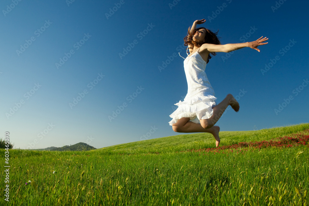 Beautiful young woman jumping on the field Beautiful young woman jumping on the field