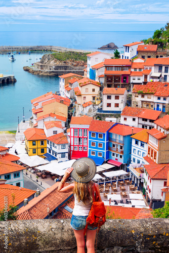 Traveler woman tourist enjoying beautiful fishing village in Asturias, Cudillero in Spain photo