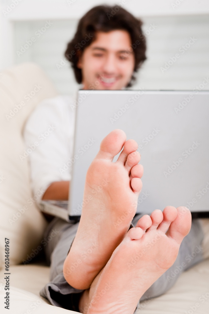 closeup shoot of computer, focus on man foot closeup shoot of computer, focus on man foot