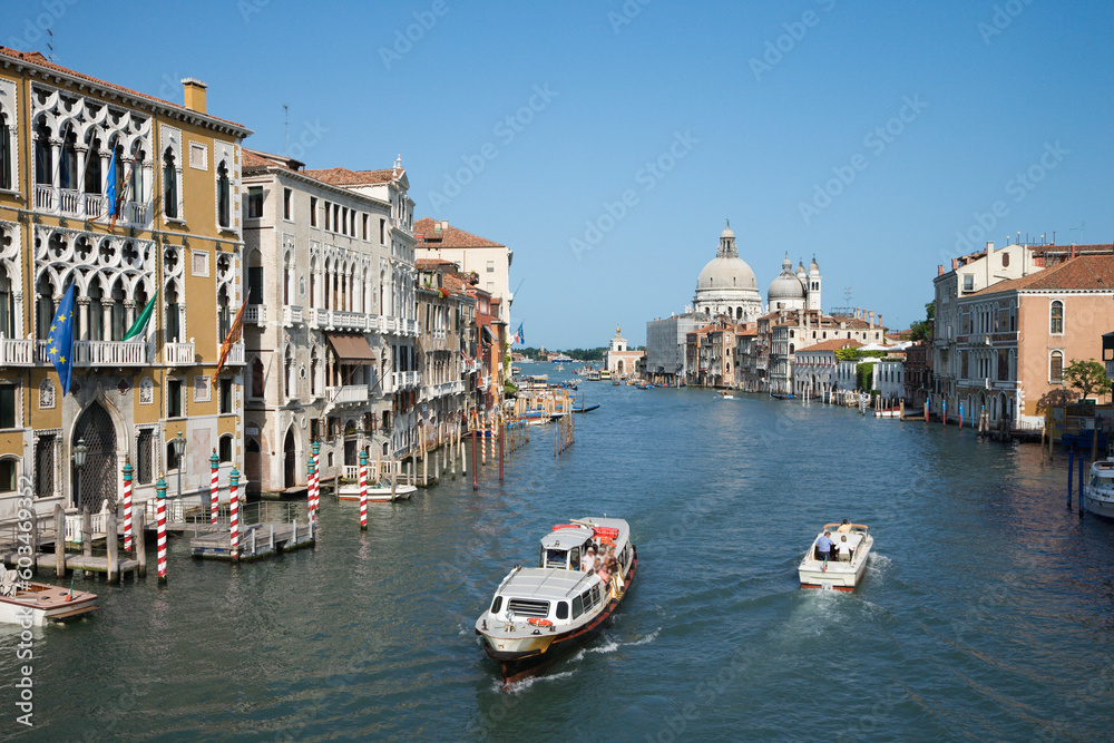 Boats on a canal surrounded by old world buildings in Venice, Italy. Horizontal shot.