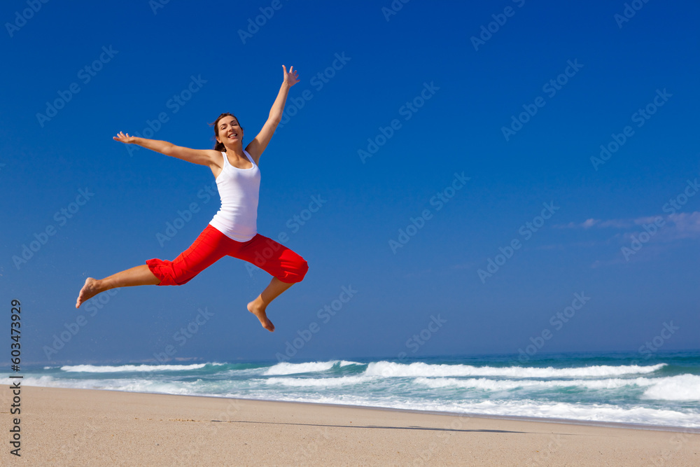 Beautiful young woman jumping on  the beach