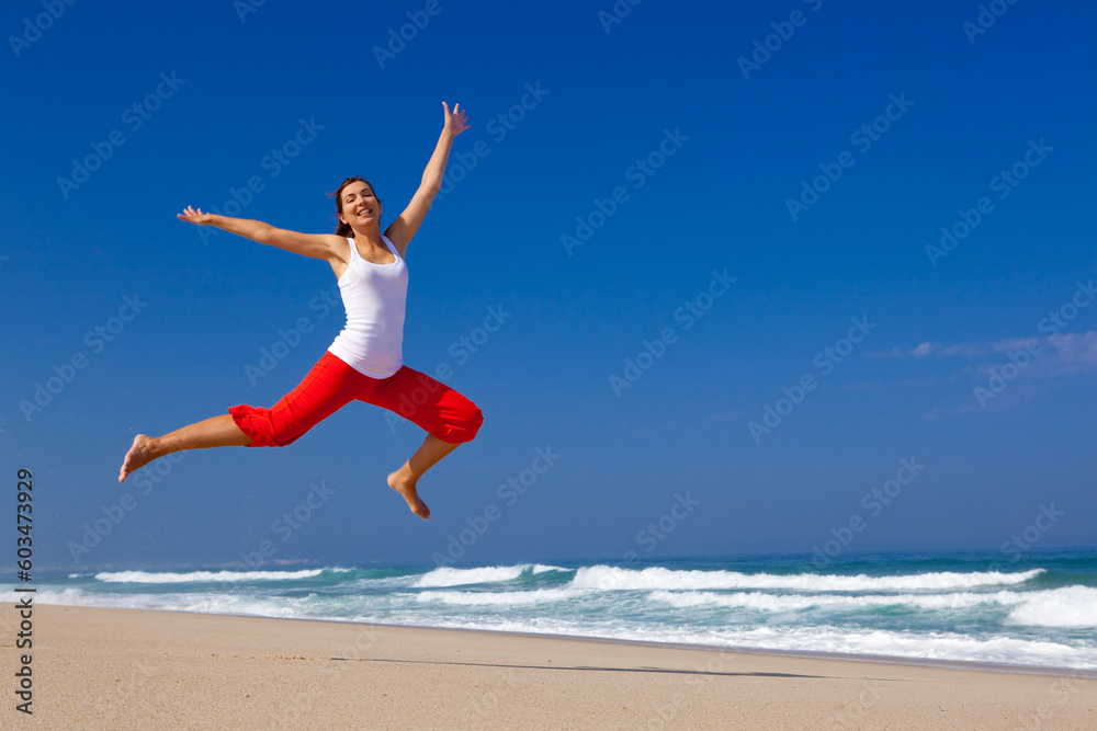 Beautiful young woman jumping on the beach Beautiful young woman jumping on the beach