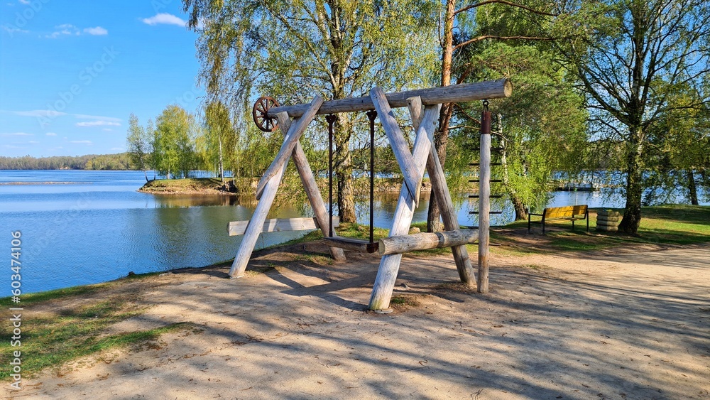 Large swing made of thick logs is built on the banks of the river Large swing made of thick logs is built on the banks of the river