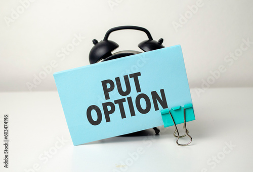 put option is written in a blue sticker near a black alarm clock