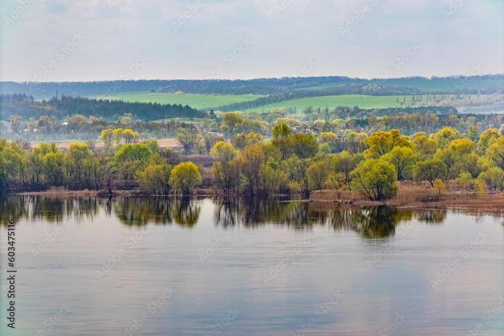 Spring landscape of the banks of the Dnieper river (Dnipro) from a height. Trees and fields, view of the horizon. View from above Spring landscape of the banks of the Dnieper river (Dnipro) from a height. Trees and fields, view of the horizon. View from above