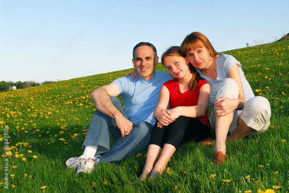 Portrait of a happy family of three on blooming summermedow Portrait of a happy family of three on blooming summermedow