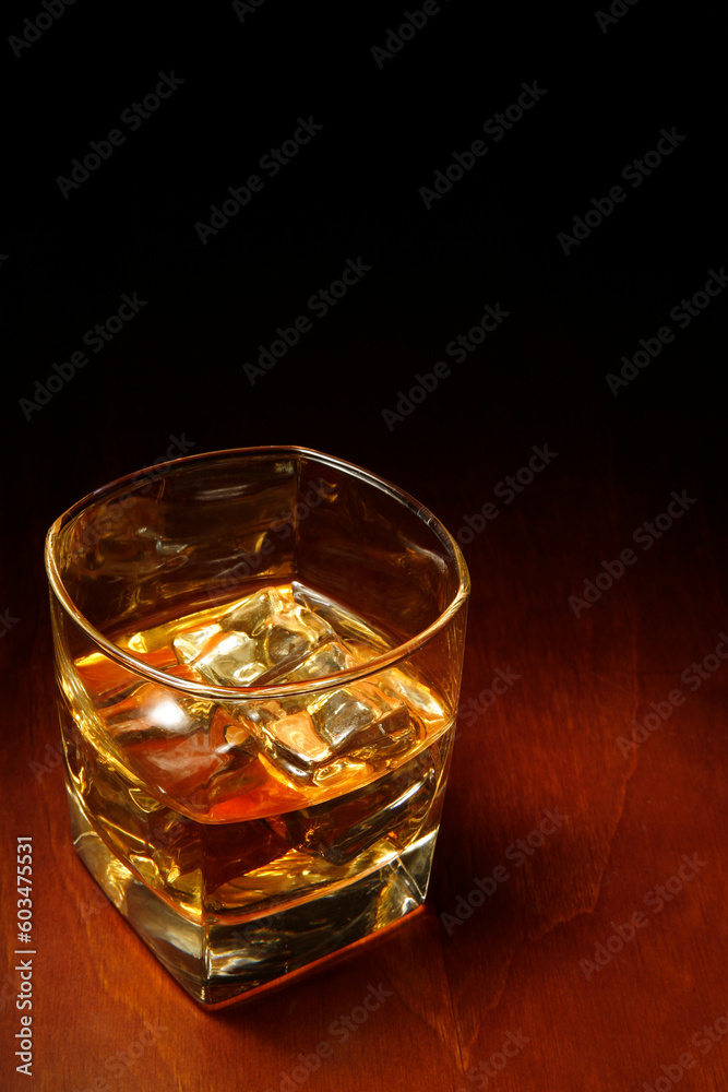 Whiskey in light pool on brown table with copyspace