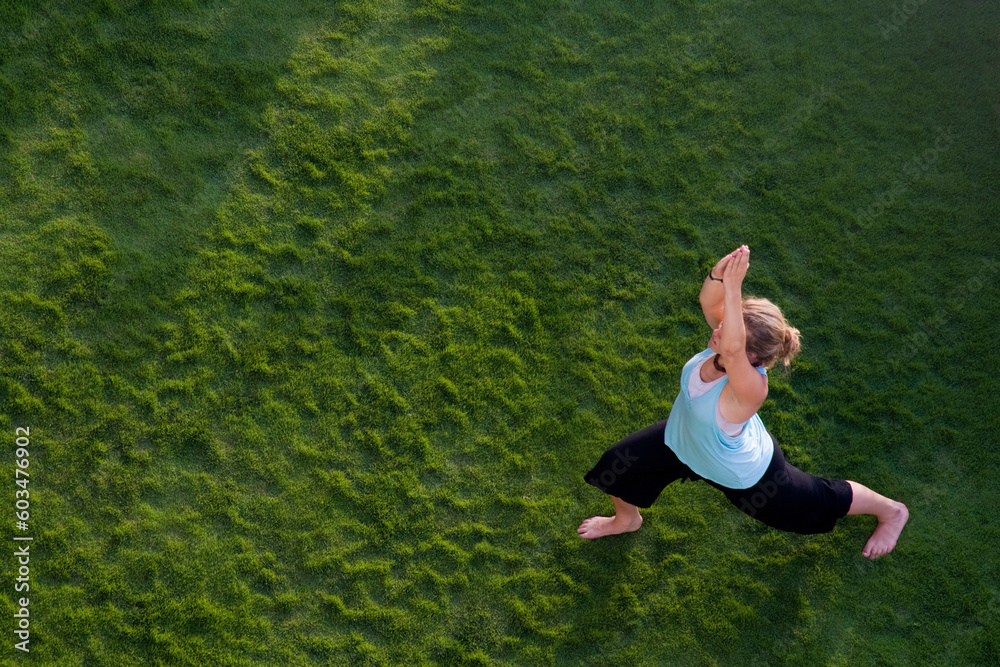 Woman doing yoga in the grass. Shot from above. Woman doing yoga in the grass. Shot from above.
