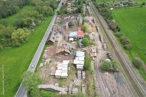 Aerial view of stacked logs near a railway yard, showcasing industrial timber storage and its role in the logistics of wood transportation photo