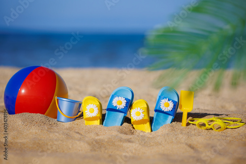 Kids flip-flops, beach ball and snorkel on the sand. Summer vacation concept