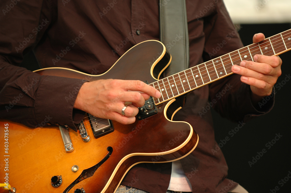 A man is playing his guitar.