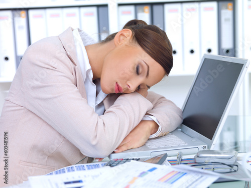 Beautiful business woman laying on desk and sleeping
