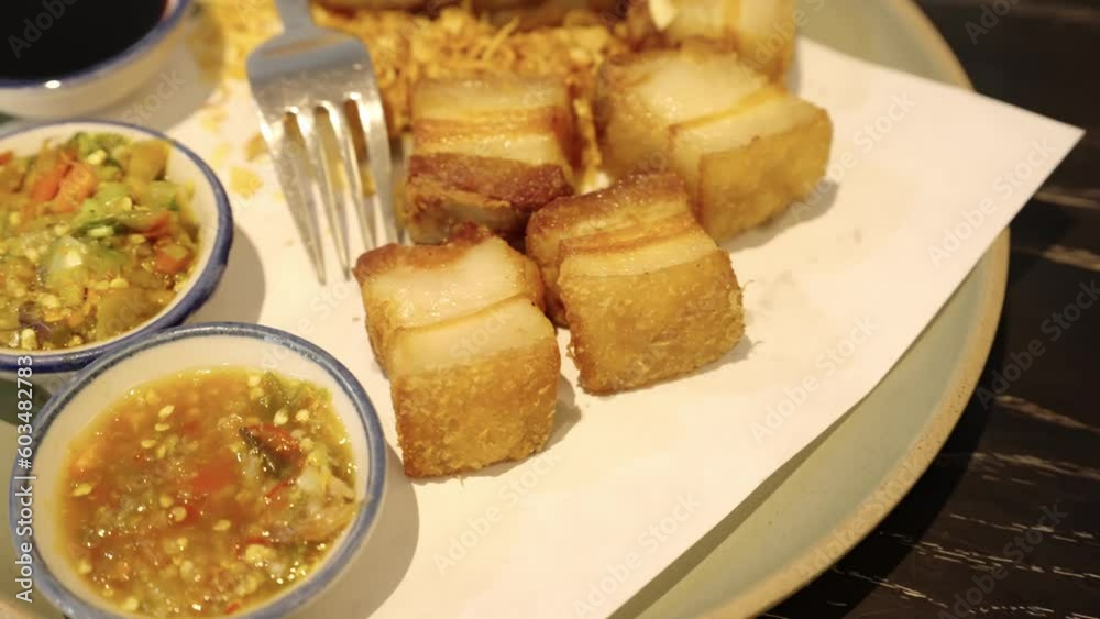 4k video, Deep-fried pork belly with fish sauce and spicy dipping sauce. Streaky pork fried with fish sauce served with black sweet sauce. Selective and shift focus 4k video, Deep-fried pork belly with fish sauce and spicy dipping sauce. Streaky pork fried with fish sauce served with black sweet sauce. Selective and shift focus