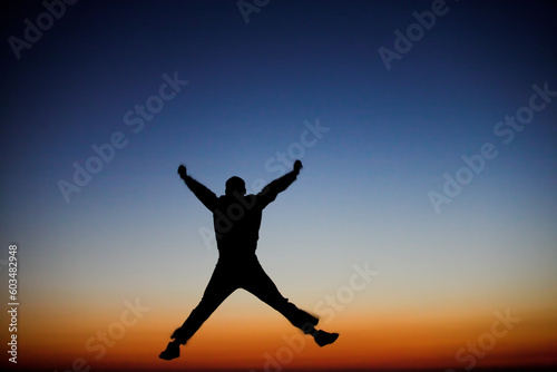 Silhouette of a man jumping against the sunset