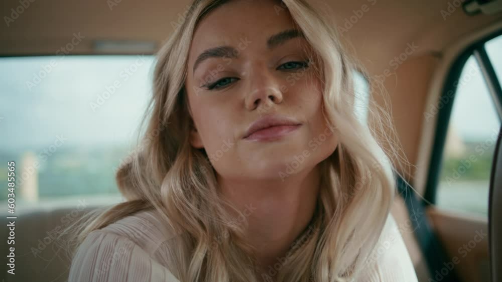 Portrait attractive woman passenger sitting retro car back seat looking camera. 