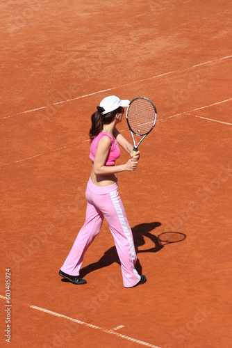 Girl playing tennis outdoor on court © Designpics
