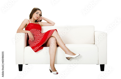 Beautiful woman with a red dress seated on a white couch