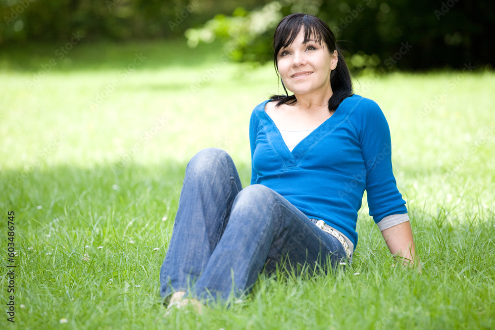 attractive woman relaxing on grass in park attractive woman relaxing on grass in park